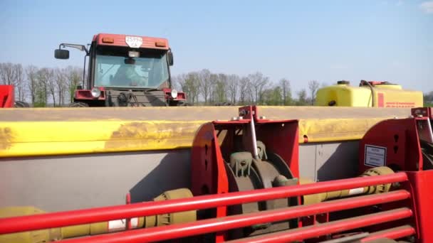 UCRAINA, CHERKASY, 5 MAGGIO 2019: primo piano, processo di impianto meccanizzato di patate da macchina. trattore di grandi dimensioni con attrezzature speciali e semi di patate, passeggiate attraverso il campo di terra nera arato, patate delle piante — Video Stock