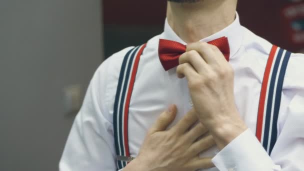 Gros plan, vue de derrière, un homme s'habille de papillon rouge . — Video