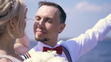 güzel çift yeni evliler. portre, damat mavi deniz ve gökyüzüne karşı, gülümsüyor, gelin aşık görünüyor. yaz güneşli gün. Düğün