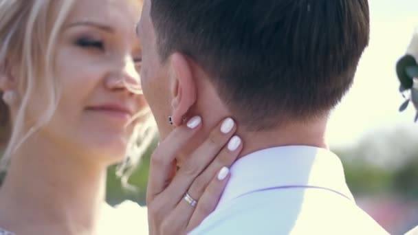 Nahaufnahme, Porträt, Braut streicht sanft über den Hals des Bräutigams. Sehen Sie einander an. Hochzeit. Sommertag — Stockvideo