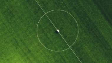 havadan video, yukarıdan görünümü, stadyumda, yeşil bir futbol sahasının merkezinde, düğün kıyafetleri dans yeni evliler, iplik. bahar güneşli bir gün. Düğün