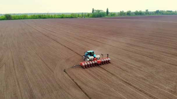 Indagine aerea, primavera, un trattore con fioriere di precisione speciale sta lavorando nel campo, c'è una piantagione di mais, o girasole. stagione di semina in azienda. tecnologie moderne in agricoltura . — Video Stock