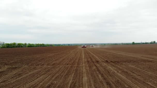 Levantamiento aéreo, primavera, hay dos tractores en el campo con sembradoras de precisión especial, maíz se planta, o girasol. En el campo es el sistema de riego. temporada de siembra en la granja. tecnologías modernas en — Vídeo de stock