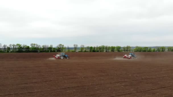 Levantamiento aéreo, primavera, hay dos tractores en el campo con sembradoras de precisión especial, maíz se planta, o girasol. En el campo es el sistema de riego. temporada de siembra en la granja. tecnologías modernas en — Vídeos de Stock