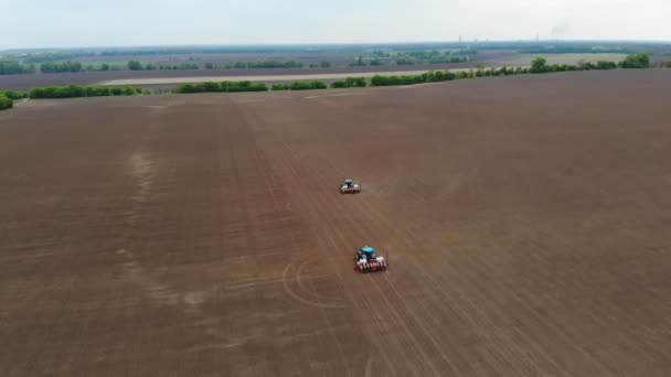 levé aérien, vue de dessus, printemps, il y a deux tracteurs dans le champ avec des planteurs de précision spéciaux, le maïs est planté, ou tournesol. saison de semis à la ferme. technologies modernes dans l'agriculture .