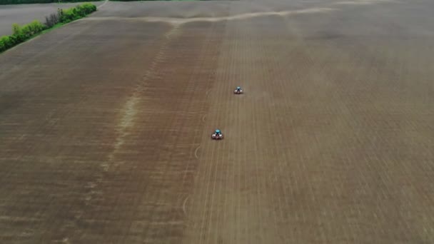 Levé aérien, vue de dessus, printemps, il y a deux tracteurs dans le champ avec des planteurs de précision spéciaux, le maïs est planté, ou tournesol. saison de semis à la ferme. technologies modernes dans l'agriculture . — Video