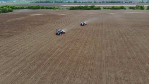 Аэросъемка, вид сверху, весна, есть два трактора в поле со специальными высокоточными плантаторами, кукуруза посажена, или подсолнечник. посевной сезон на ферме. современные технологии в сельском хозяйстве . — стоковое видео