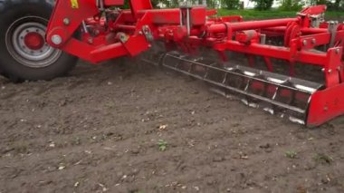 yakın çekim, traktör kültivatörü yetiştirir, toprağı kazar. traktör alanı pulluklar. taze sürülmüş arazi içine çiftlikte toprak kazma küçlük için otomatik çapa makinesi. Bahar