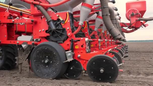 Primo piano, coltivatore trattore coltiva, scava il terreno. trattore aratri il campo. fresatrice automatizzata per lo scavo del terreno in azienda in terreni appena arati. primavera — Video Stock