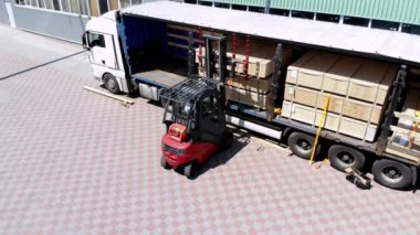 aero, depolar. kamyonun boşaltılması. kamyondan depoya mal boşaltma. Forklift, kamyondan depoya kargoyu açık havada koyuyor.