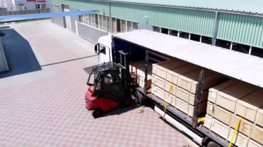 Ambar. kamyonun boşaltılması. kamyondan depoya mal boşaltma. Forklift, kamyondan depoya kargoyu açık havada koyuyor.