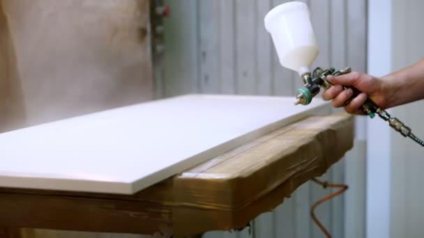 Close-up. Mancha de madeira com pistola de pulverização. Pintor usando aerógrafo para pintar — Vídeo de Stock