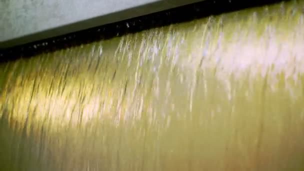 Γκρο πλαν. σε μια ειδική μηχανή, μια υγρή λάκα επίπλων από ελαφρύ κίτρινο χρώμα ρέει. καλύπτοντας τις προσόψεις επίπλων με βερνίκι — Αρχείο Βίντεο