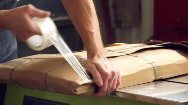 Imballaggi mobili prodotti. primo piano. L'operaio avvolge accuratamente gli elementi di arredo in imballaggi di cartone, li prepara per il trasporto . — Video Stock