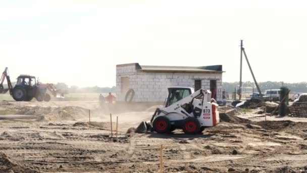 CHERKASY, UCRANIA, 20 DE SEPTIEMBRE DE 2019: obra, construcción. La técnica funciona. mini excavadora limpia el sitio, elimina el exceso de suelo — Vídeo de stock