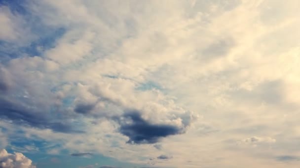 Timelapse, Sunset. nubes blancas, asombrosamente hermosas y aireadas están corriendo contra el cielo azul en los rayos de luz. las profundidades del cielo son como el mar — Vídeos de Stock