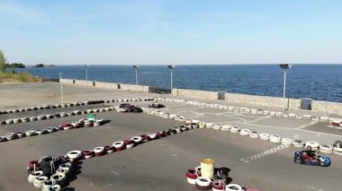 Aero, üst manzara. Go-kart açık havada yarışıyor. Eski tekerleklerden yapılmış güvenlik bariyerleri var. Yaz