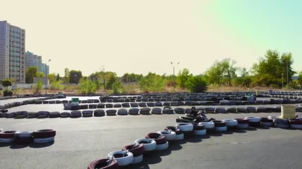 Young go cart race on circuit outdoors. There are safety barriers made of old wheels . Ten years old girl drives go-kart. Go-cart racing. Summer — Stock Video