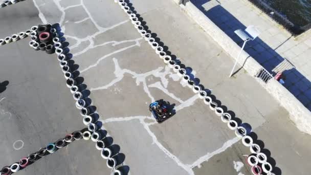 エアロ最上階だ屋外サーキットでのゴーカートレース。古い車輪で作られた安全障壁があります。夏 — ストック動画