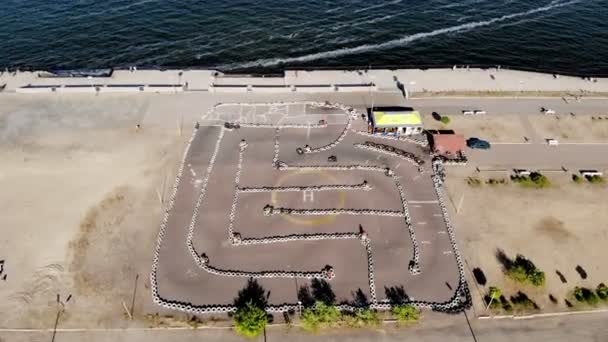 Aero, bovenaanzicht. Go-cart racen op circuit buiten. Er zijn veiligheidsbarrières gemaakt van oude wielen. Zomer — Stockvideo