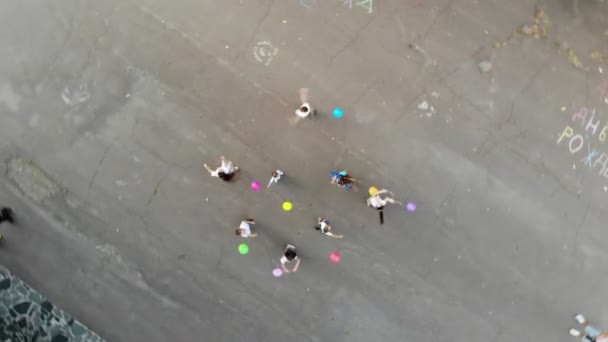 CHERKASY, UCRANIA, 5 DE OCTUBRE DE 2019: Aero, vista superior. Danza redonda. niños giran, giran, bailan alegremente, con globos. en el parque, en el pavimento. verano — Vídeo de stock