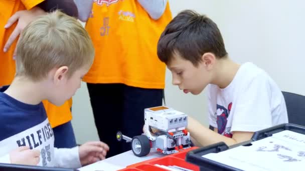 CHERKASY, UKRAINE, OCTOMBRIE 19, 2019: copiii școlari, băieții se joacă cu un designer de jucării, creează diverse mașini, roboți de piese de designer neferoase, blocuri colorate. jocuri educative pentru copii — Videoclip de stoc