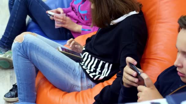 Adolescents enfants utilisent des gadgets, smartphones, chat dans les réseaux sociaux. le concept de dépendance des enfants aux téléphones et tablettes — Video