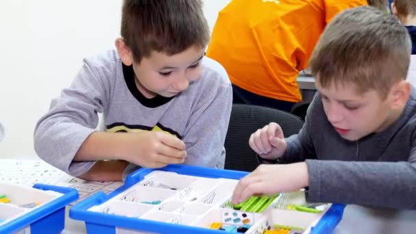 Okul çocukları, çocuklar bir tasarımcıyla çalışıyor, çeşitli makineler yapıyorlar, demirsiz parçalar tasarlayan robotlar, bloklar. Robot Bilimi Okulu, Kök Eğitimi. — Stok video
