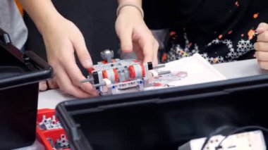 Eğitimdeki çizimlere göre, öğrenciler tasarımcıyı kullanarak bir cihaz yaratıyorlar. Robot Bilimi Okulu, Kök Eğitimi.