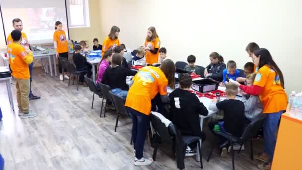 Cherkasy, Ουκρανία, 19 Οκτωβρίου 2019: μαθητές, αγόρια και κορίτσια, εργάζονται με έναν σχεδιαστή, δημιουργούν διάφορες μηχανές, ρομπότ σχεδιαστών μη σιδηρούχων μερών, μπλοκ. Σχολή Ρομποτικής, Στεατική εκπαίδευση. — Αρχείο Βίντεο