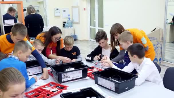 Cherkasy, Ukraina, 19 oktober 2019: skolbarn, pojkar och flickor, arbetar med en designer, skapa olika maskiner, robotar av designer icke-järnhaltiga delar, block. Robotics skola, Stamutbildning. — Stockvideo