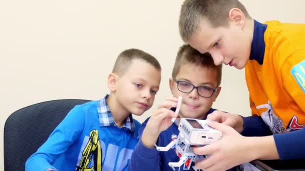 CHERKASY, UKRAINE, OCTOBER 19, 2019: students, children, boys and girls, create devices using the designer, non-ferrous parts, blocks, according to drawings in instructions on tablets. School of — Stock Video