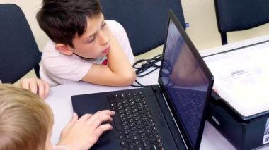 Bilgisayar dersinde dizüstü bilgisayarda çalışan öğrenciler klavyede yazı yazıyorlar. okul ve eğitim