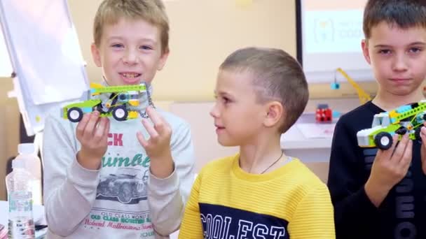 Niños de la escuela muestran sus coches, máquinas, hechas de partes de colores del diseñador. Escuela de Robótica, educación STEM — Vídeo de stock