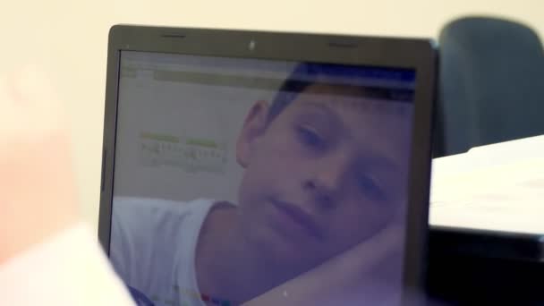 Yakın plan, dizüstü bilgisayarda çalışan bir çocuk. Çocuğun yüzü monitörde yansıyor. okul ve eğitim — Stok video