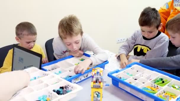 Studenti, bambini, ragazzi e ragazze, creare dispositivi utilizzando il progettista, parti non ferrose, blocchi, secondo i disegni nelle istruzioni su tablet. Scuola di Robotica, Educazione STEM . — Video Stock