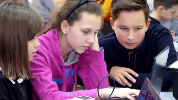 Los escolares que trabajan juntos en un ordenador portátil en la clase de informática, escribiendo en un teclado. escuela y educación — Vídeo de stock