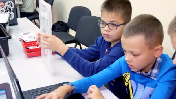 Cherkasy, Oekraïne, 19 oktober 2019: Schoolkinderen werken samen op een laptop in computerles, typen op een toetsenbord. school en onderwijs — Stockvideo
