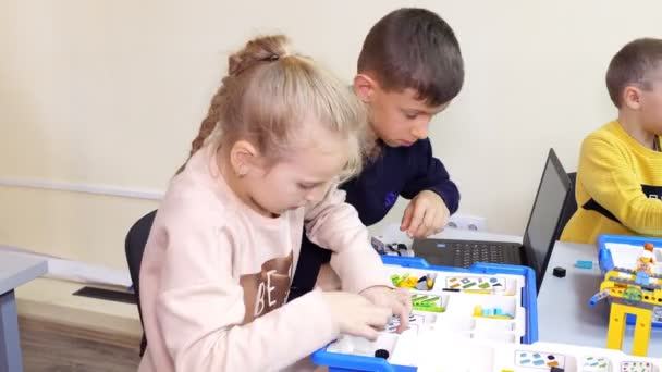 Students create devices, machines, using the designer, according to the instruction in the laptop . School of Robotics, STEM education — ストック動画
