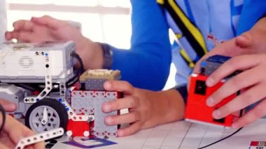 Yakın plan, çocuklar tasarımcının küçük parçalarından yapılmış arabalarla oynuyorlar. Robotik okulunda bir tasarımcıdan alınan makinelerle ilgili eğitici bir ders. Kök eğitim