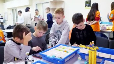 Cherkasy, Ukrayna, 19 Ekim 2019: öğrenciler, çocuklar, oğlanlar ve kızlar, tabletlerdeki talimatlara göre tasarımcı, demir olmayan parçalar, bloklar kullanan cihazlar yaratıyorlar. Okul...