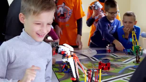 CHERKASY, UCRANIA, 19 DE OCTUBRE DE 2019: niño juega con un robot hecho de pequeños detalles de diseño. robot se mueve, puede realizar ciertas acciones. lección educativa en la escuela de robótica, educación STEM — Vídeo de stock