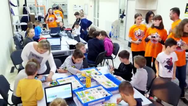 Czerkasy, Ukraina, 19 października 2019: studenci, dzieci, chłopcy i dziewczęta, tworzyć urządzenia przy użyciu projektanta, części nieżelazne, bloki, zgodnie z rysunkami w instrukcjach na tabletach. Szkoła — Wideo stockowe