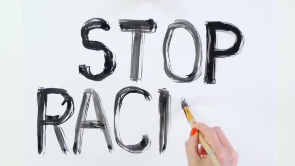 Zeitraffer. Nahaufnahme, Hand schreibt Slogan - Stop Racism - mit Pinsel, mit schwarzer Aquarellfarbe auf weißem Banner, Plakat. Kampf gegen Rassismus, für gleiche Rechte in den USA. — Stockvideo