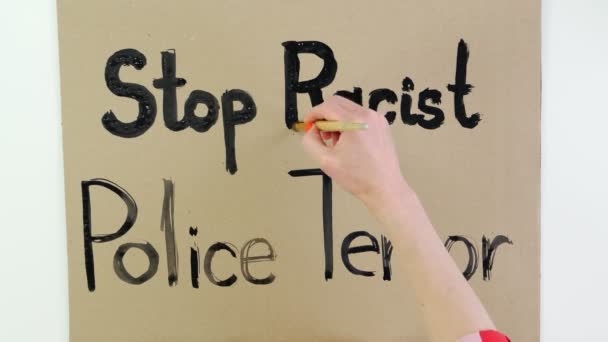 Timelapse. närbild, skriver hand slogan - Stoppa rasistiska polisen Terror - med pensel, med svart färg på papp banner. Kampen mot rasism, för lika rättigheter i USA. — Stockvideo