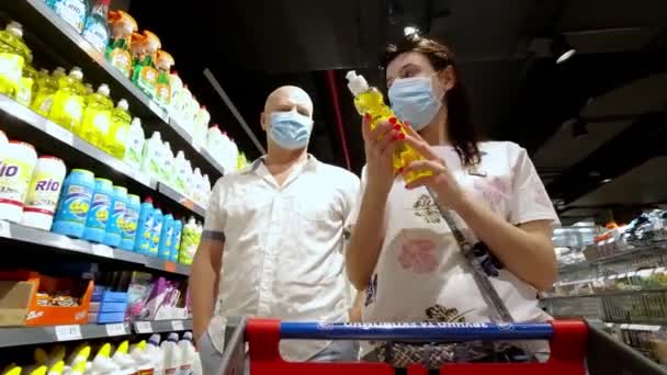 CHERKASY, UCRAINA, 4 GIUGNO 2020: coppia sposata, indossa maschere mediche usa e getta e fa shopping al supermercato durante l'epidemia di covid-19 . — Video Stock