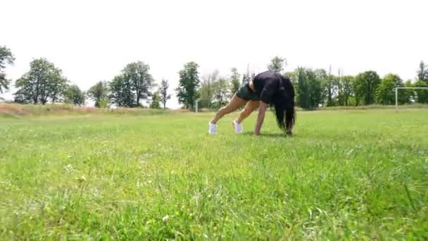 Donna di idoneità in abbigliamento sportivo che fa vari esercizi su erba verde di campo di sport, a stadio. Sport all'aria aperta. formazione online. caldo giorno d'estate. concetto di stile di vita sano — Video Stock