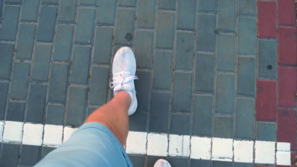 Close-up, top view. male legs in white sneakers cross the white line and go to the number 600, drawn on the floor. — Stock Video