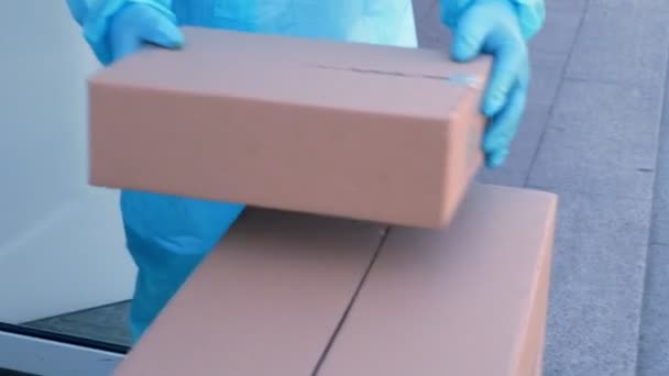 Close-up, Delivery of parcels with medical equipment or drugs to hospital during coronavirus outbreak. Courier, in protective suit, is handing cardboard boxes to nurse. Cargo delivery service during — Stock Video