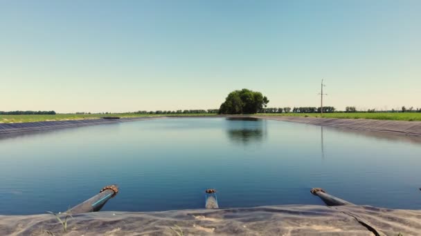 アエロ。パイプで灌漑貯水池。人工的に作られた特別な貯水池農業分野の灌漑用タンク。近くに水の汲み上げ場があります。農業. — ストック動画